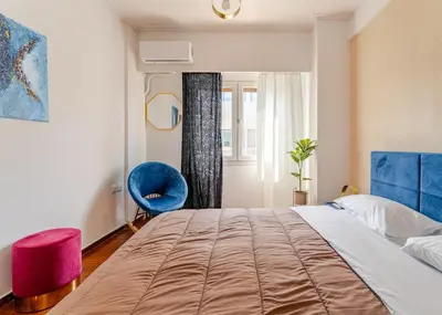 a bedroom with a large bed and a blue chair at Amazing Luxurious BrandNew 4BDR 2Bath ΑcropolisAPT in Athens
