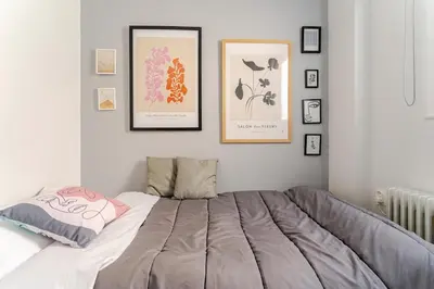 a bedroom with a bed with pictures on the wall at Amazing Luxurious BrandNew 4BDR 2Bath ΑcropolisAPT in Athens