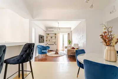 a living room with a table and blue chairs at Amazing Luxurious BrandNew 4BDR 2Bath ΑcropolisAPT in Athens