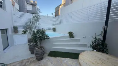 a courtyard with potted plants and a swimming pool at Myronos suite with jacuzzi in Piraeus