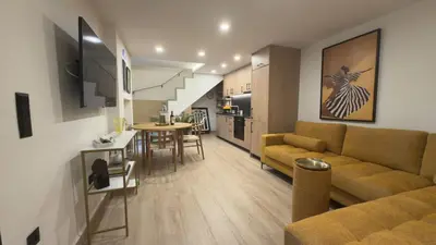 a living room with a couch and a table and a kitchen at Myronos suite with jacuzzi in Piraeus