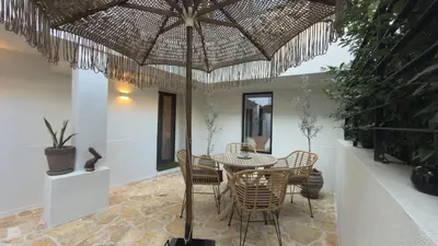 a dining room with a table and chairs under an umbrella at Myronos suite with jacuzzi in Piraeus