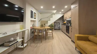 a kitchen and living room with a table and a couch at Myronos suite with jacuzzi in Piraeus
