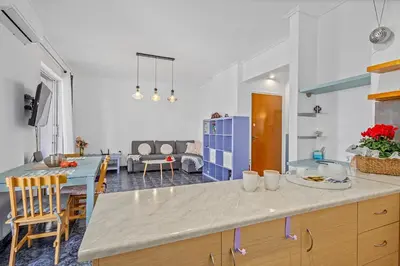 a kitchen with a counter and a living room at h2h Levandre Kallithea near Metropolitan, in Athens