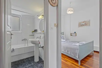 a white bathroom with a sink and a bed at h2h Levandre Kallithea near Metropolitan, in Athens