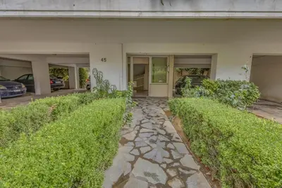 a stone walkway in front of a house with bushes at h2h Levandre Kallithea near Metropolitan, in Athens