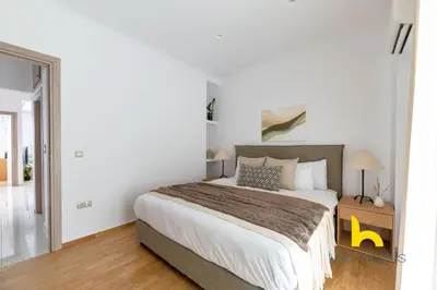 a bedroom with a large bed with white walls at Chic Koukaki Haven Steps to Metro & Acropolis! in Athens