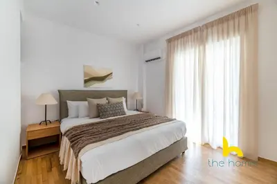 a bedroom with a large bed and a large window at Chic Koukaki Haven Steps to Metro & Acropolis! in Athens