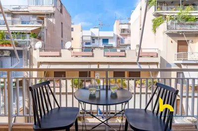 a balcony with a table and chairs on a balcony at Chic Koukaki Haven Steps to Metro & Acropolis! in Athens