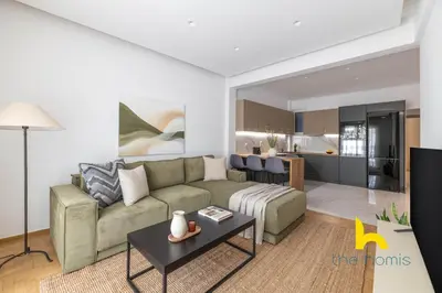 a living room with a couch and a table at Chic Koukaki Haven Steps to Metro & Acropolis! in Athens