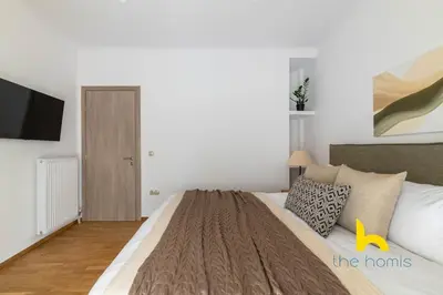 a bedroom with a large bed and a tv at Chic Koukaki Haven Steps to Metro & Acropolis! in Athens