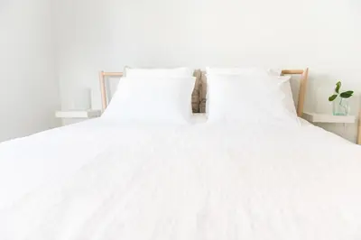 a white bed with white sheets and pillows at Urban Piraeus, Apartment No 2 in Piraeus