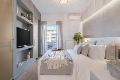 a white bedroom with a large bed and a tv at 50 Shades of Athens, Kingsize Suite with Jacuzzi! in Athens