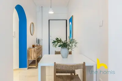 a dining room with a table with a vase on it at Aegean Blue Hideaway w Fireplace, near Acropolis in Athens