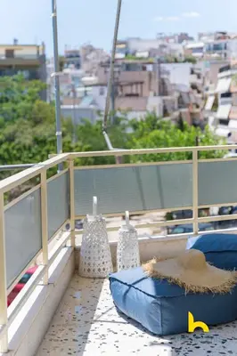 a balcony with two blue pillows and a view of a city at Aegean Blue Hideaway w Fireplace, near Acropolis in Athens