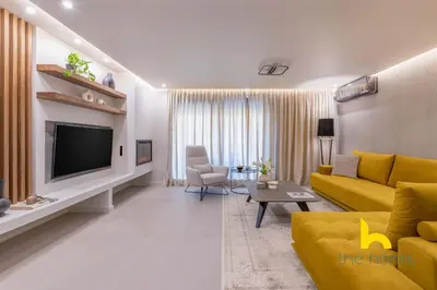 a living room with a yellow couch and a television at Majestic Acropolis View w Large Patio & Parking in Athens