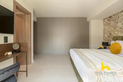 a bedroom with a large bed and a tv at Majestic Acropolis View w Large Patio & Parking in Athens