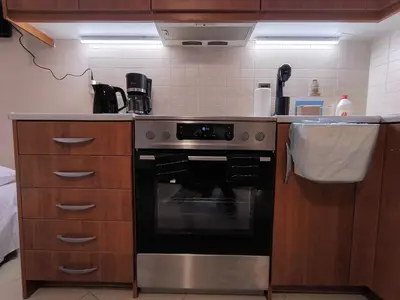 a kitchen with a stainless steel stove and cabinets at Boutique Studio 100m from the Sea in Piraeus in Piraeus
