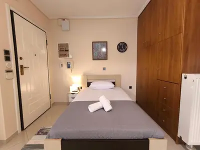 a bedroom with a bed with two towels on it at Boutique Studio 100m from the Sea in Piraeus in Piraeus