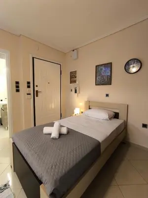 a bedroom with a bed with two towels on it at Boutique Studio 100m from the Sea in Piraeus in Piraeus