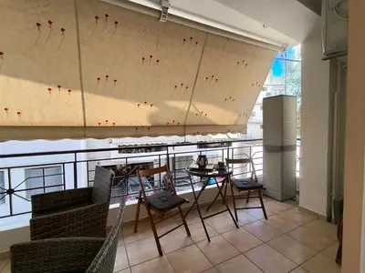 a room with a balcony with a table and chairs at Boutique Studio 100m from the Sea in Piraeus in Piraeus