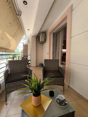 a living room with two chairs and a table at Boutique Studio 100m from the Sea in Piraeus in Piraeus