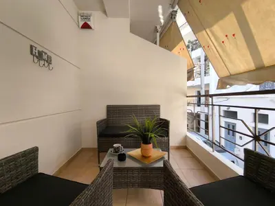 a room with chairs and a table with a plant at Boutique Studio 100m from the Sea in Piraeus in Piraeus