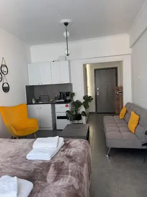 a room with a bed and a couch and a kitchen at Urban Hermes Apartment in Athens
