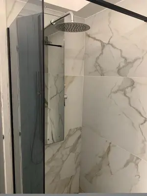 a bathroom with a shower with a glass door at Urban Hermes Apartment in Athens