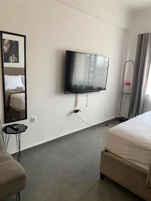 a bedroom with a flat screen tv on the wall at Urban Hermes Apartment in Athens