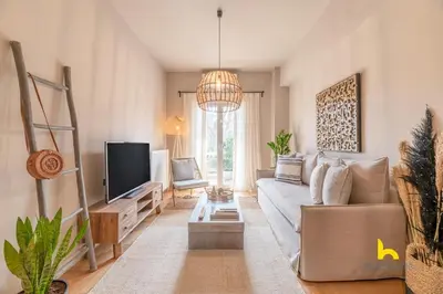 a living room with a couch and a tv at Sun-Kissed Boho Haven with Whirlpool Bliss & Patio in Athens