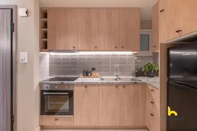 a kitchen with wooden cabinets and a sink at Sun-Kissed Boho Haven with Whirlpool Bliss & Patio in Athens