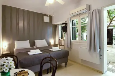 a bedroom with a bed and a table and a window at Athens Green Apartments in Athens