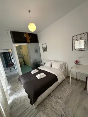 a bedroom with a large bed with two towels on it at Athens Green Apartments in Athens