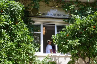 a man standing in the window of a building at Athens Green Apartments in Athens