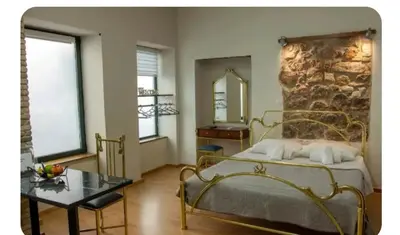 a bedroom with a bed and a stone wall at Neoclassic Rooms in Athens
