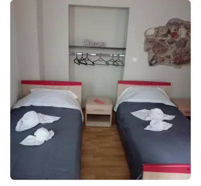 a bedroom with two beds with white hats on them at Neoclassic Rooms in Athens