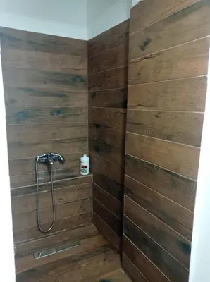 a bathroom with a shower with wooden walls at Neoclassic Rooms in Athens
