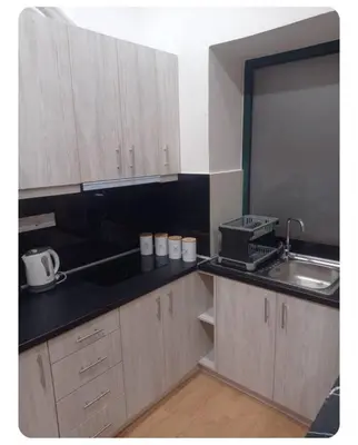 a kitchen with wooden cabinets and a sink and a counter top at Neoclassic Rooms in Athens