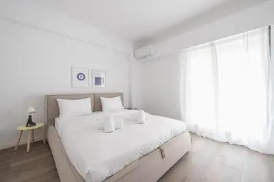 a white bedroom with a large bed with white pillows at The Art Boutique Loft in Athens