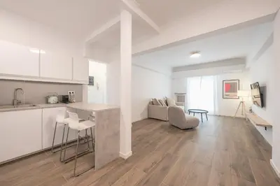 a kitchen and living room with white walls and wooden floors at The Art Boutique Loft in Athens