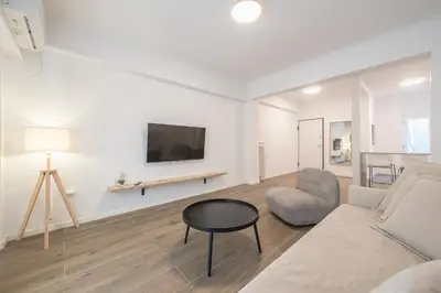 a living room with a couch and a table and a tv at The Art Boutique Loft in Athens