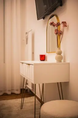 a white table with a mirror and a vase with flowers on it at Lysé Athens in Athens