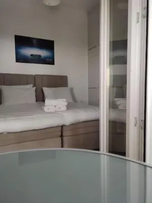 a room with a bed with a mirror and a tv at By the wave luxurious studios in Piraeus