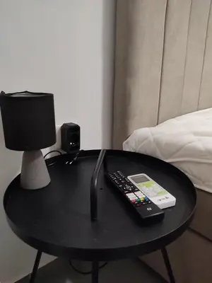 a table with a remote control and a lamp on it at By the wave luxurious studios in Piraeus