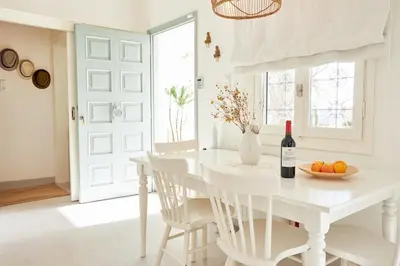 a white dining room with a white table and white chairs at Camara Athens Riviera Home in Aghia Marina