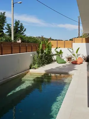 a swimming pool in the backyard of a house at Camara Athens Riviera Home in Aghia Marina