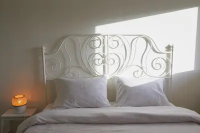 a bed with a white headboard and two pillows at Camara Athens Riviera Home in Aghia Marina