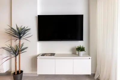 a white cabinet with a tv on a wall at Boutique Studio ΙV in Central Athens by MPS in Athens