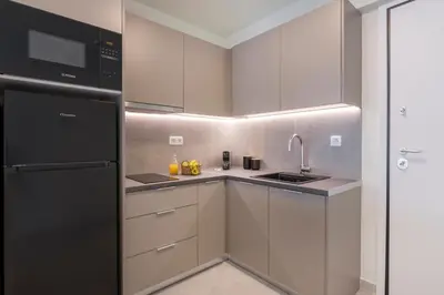 a kitchen with white cabinets and a black refrigerator at Boutique Studio ΙV in Central Athens by MPS in Athens